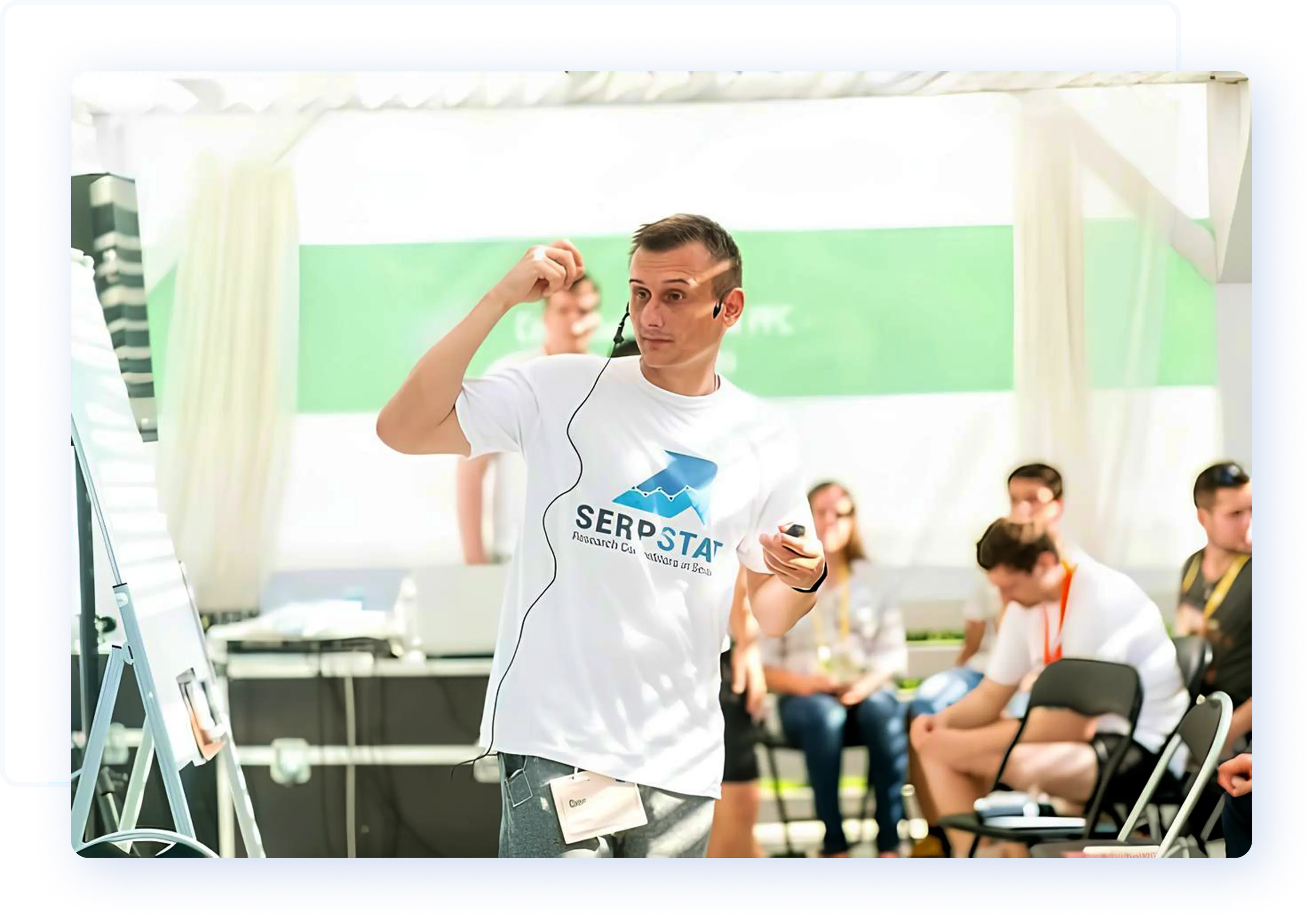 Serpstat team member presenting at a marketing conference wearing a branded Serpstat shirt