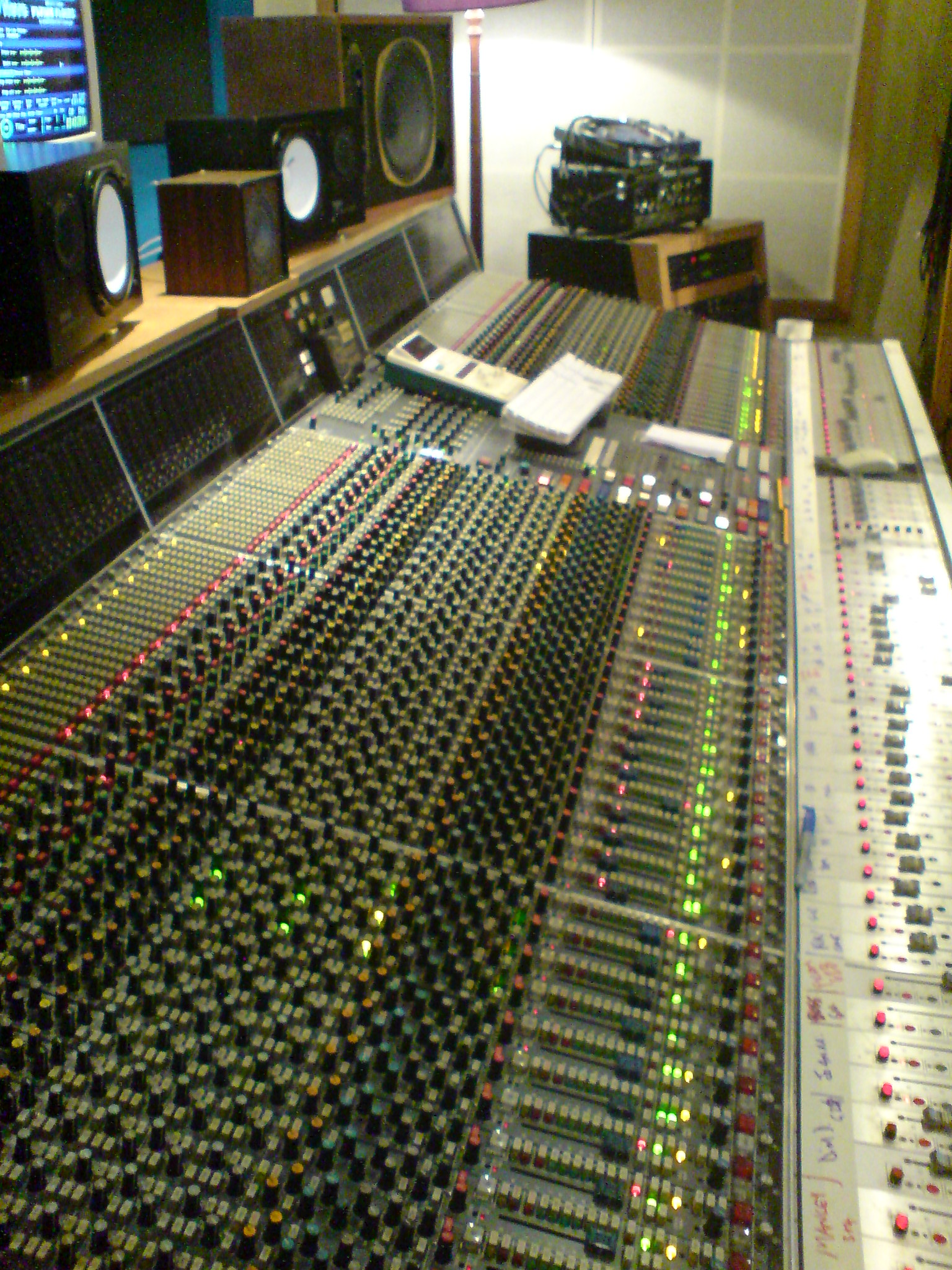 A large analog mixing console in a professional recording studio